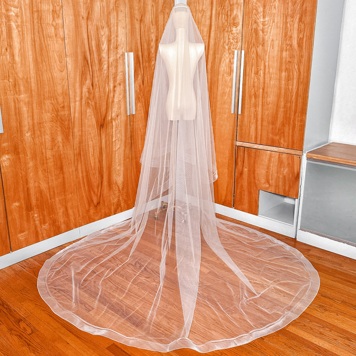 Rear view of a cathedral length double horsehair wedding veil draped on a dress form.