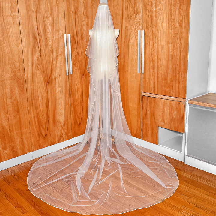 Back view of a flowing cathedral length cascade wedding veil showcasing the tiered tulle layers.
