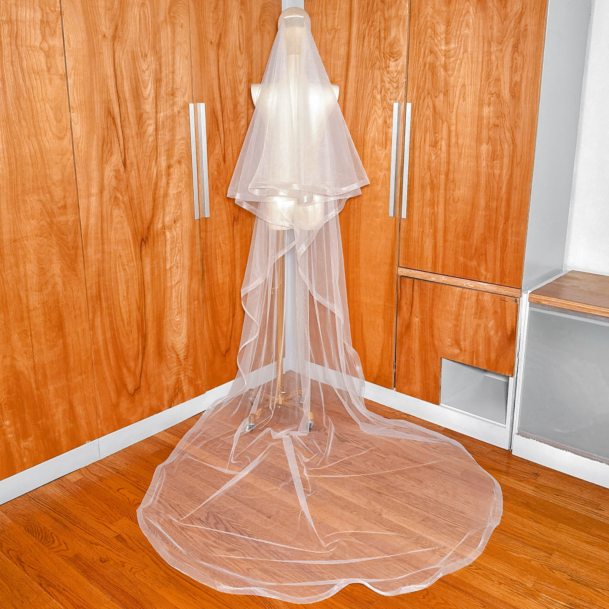 Elegant 1 1/2" horsehair trim wedding veil with blusher cascading in cathedral length.
