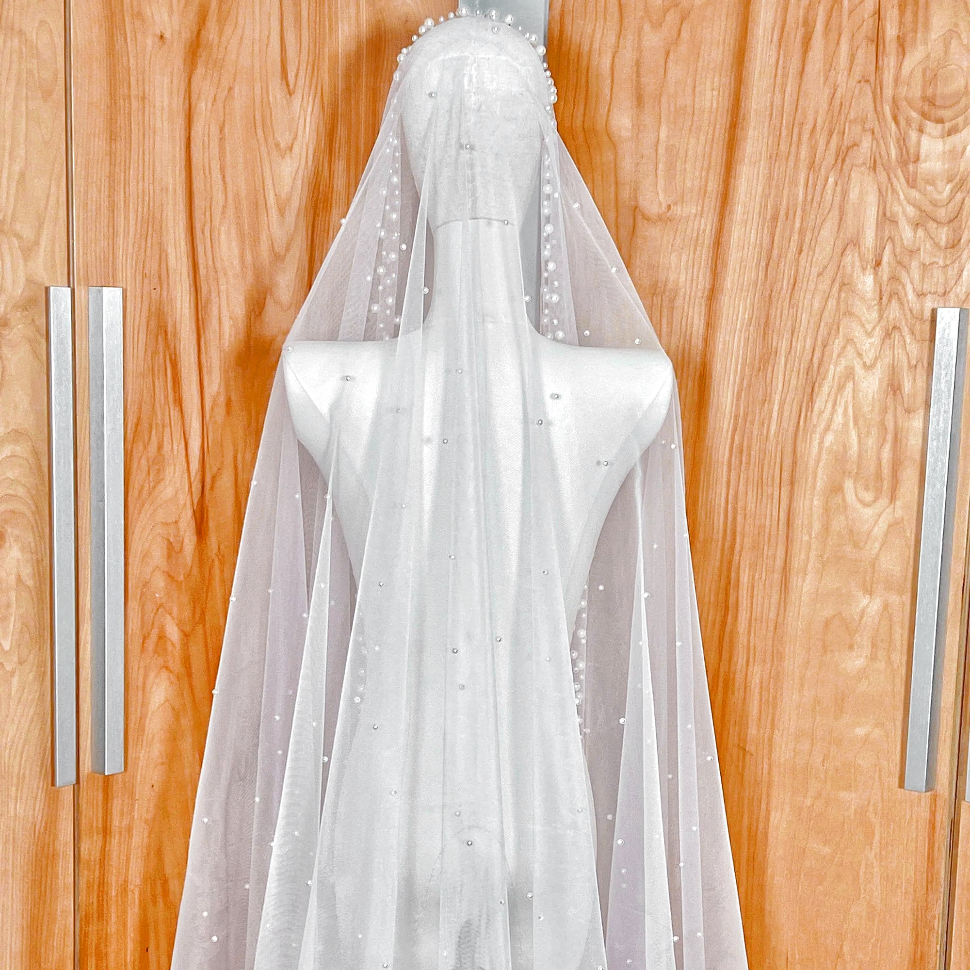 Back view showing the edge of the scattered pearl mantilla bridal veil on a bridal mannequin.