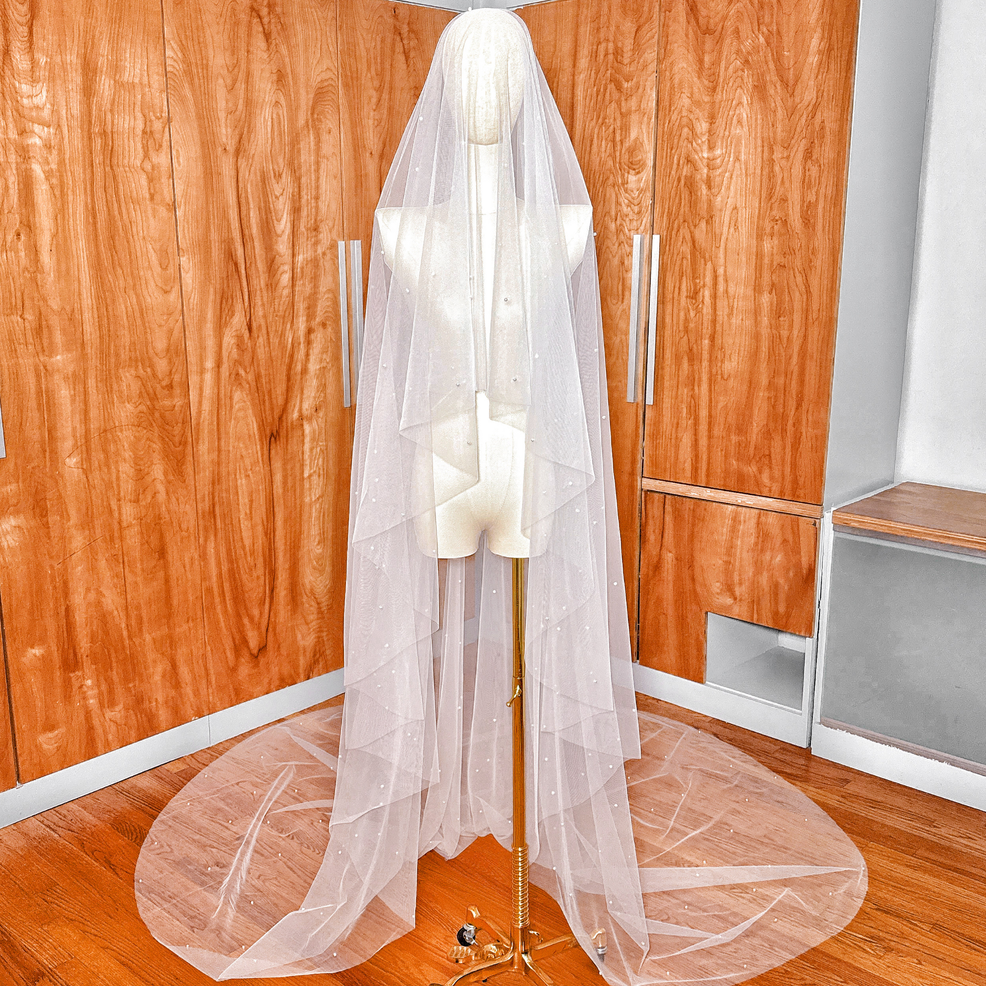 Full view of a cathedral length scattered pearl wedding veil featuring a two tier design.