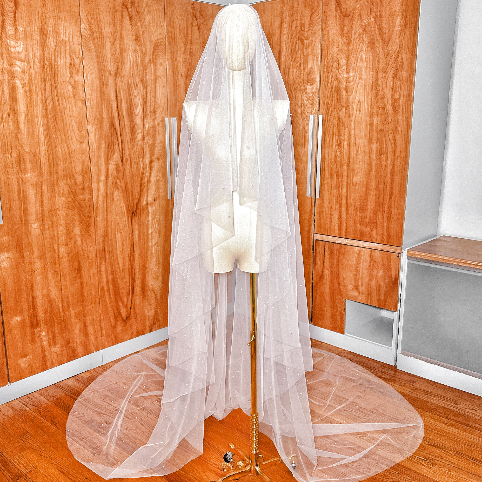 Full view of a cathedral length scattered pearl wedding veil featuring a two tier design.