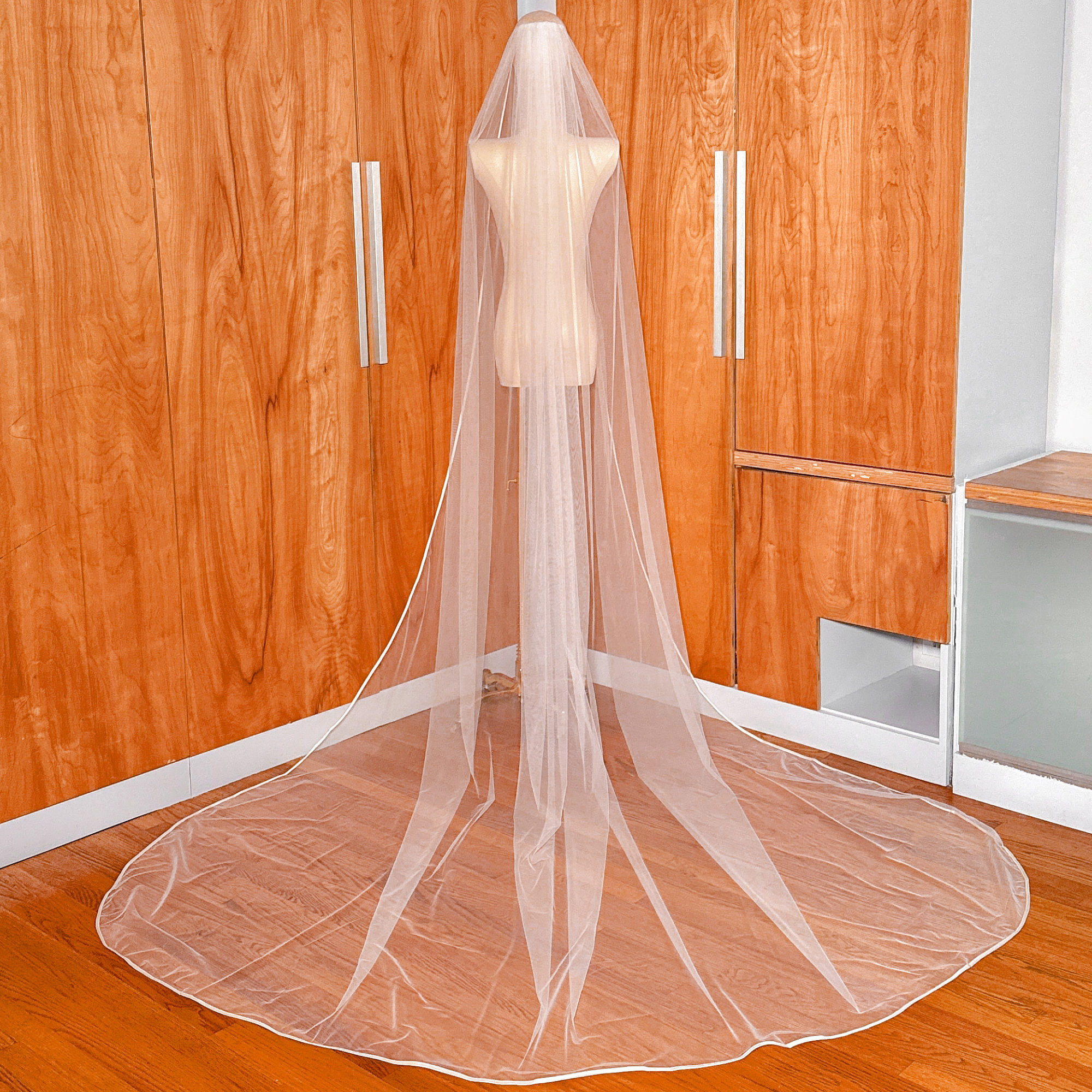 Full back view of a cathedral length single tier ribbon edge wedding veil.