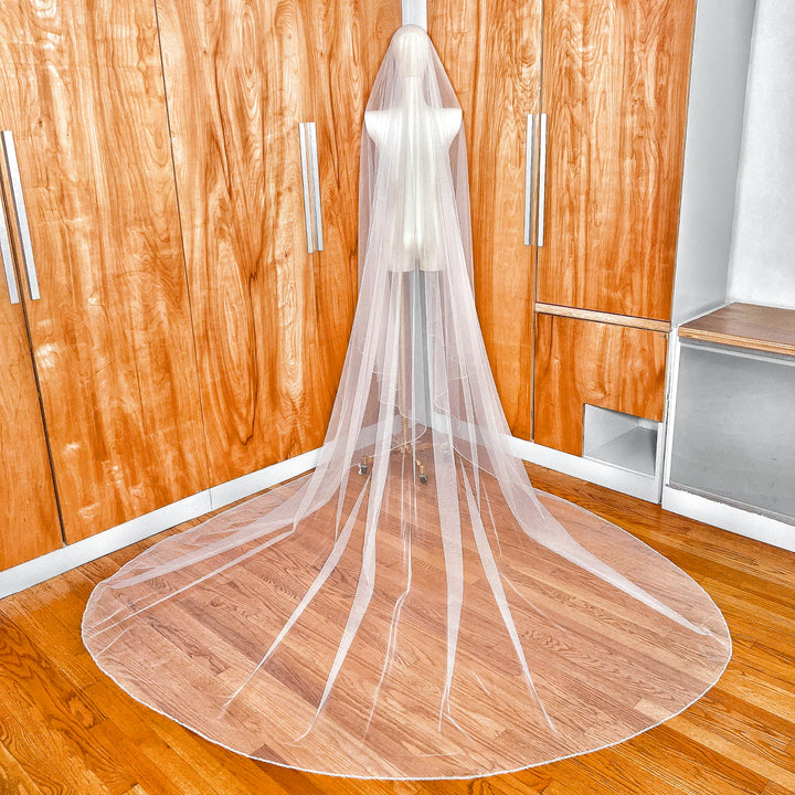 Dramatic back view of a cathedral length two tier crystal beaded edge wedding veil with blusher.
