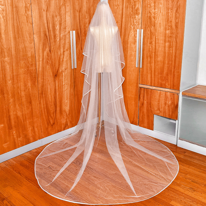 Back view of a two tier ribbon edge wedding veil with blusher flowing down in cathedral length on a mannequin.