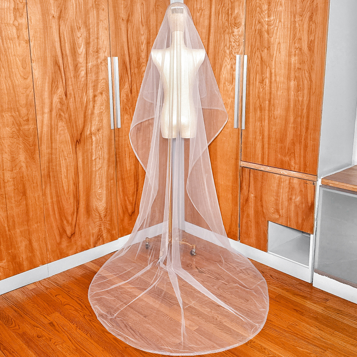 Back view of a cathedral length two-tier wedding veil featuring horsehair edging on a mannequin.
