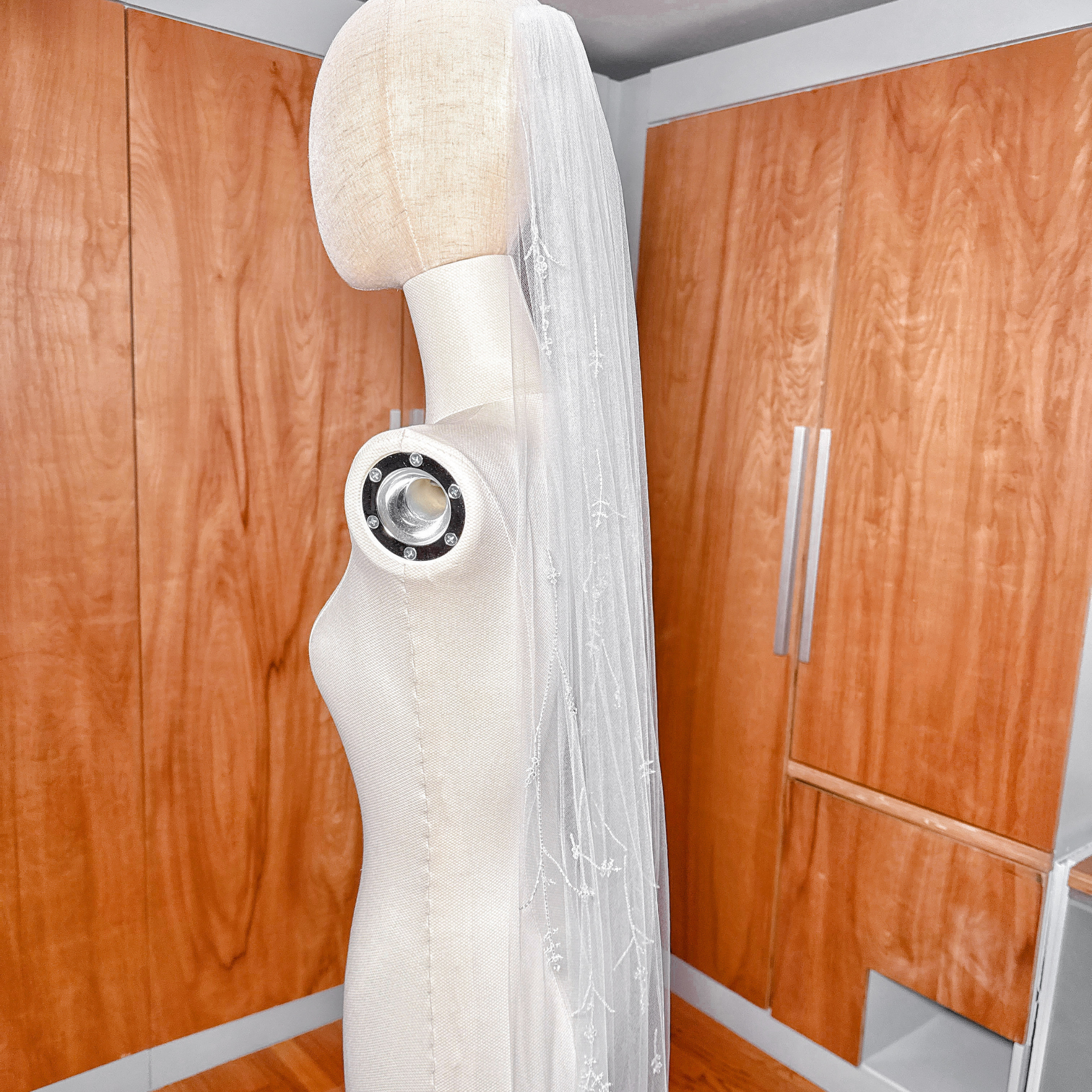 Side profile of a cathedral length 3D floral embroidered veil with crystals.