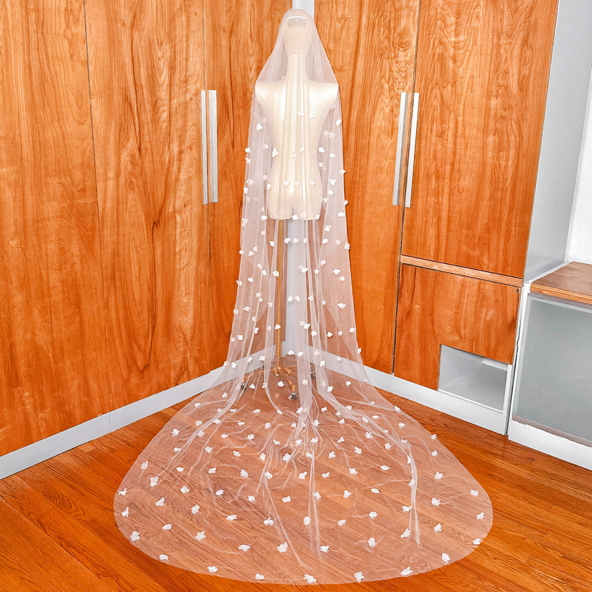 Back view of a cathedral length two tier 3D floral wedding veil with blusher on a mannequin.
