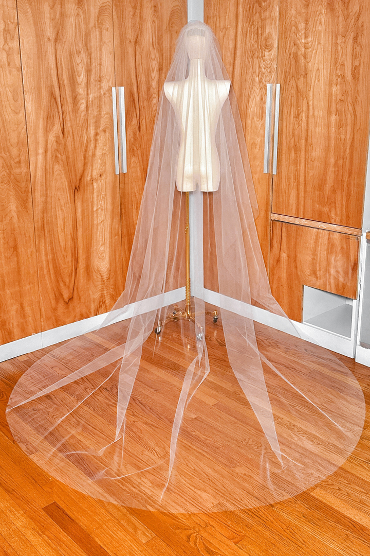 Full-length back view of a two-tier cathedral tulle wedding veil with a raw edge.