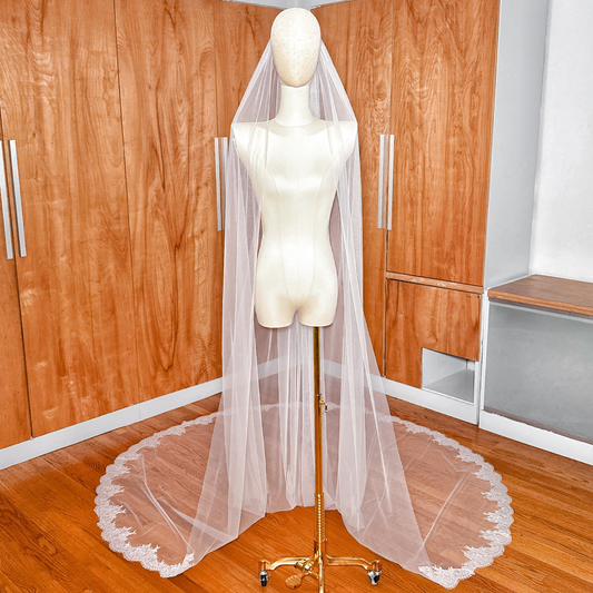 Front view of a Chantilly lace cathedral wedding veil draped over a bridal mannequin.