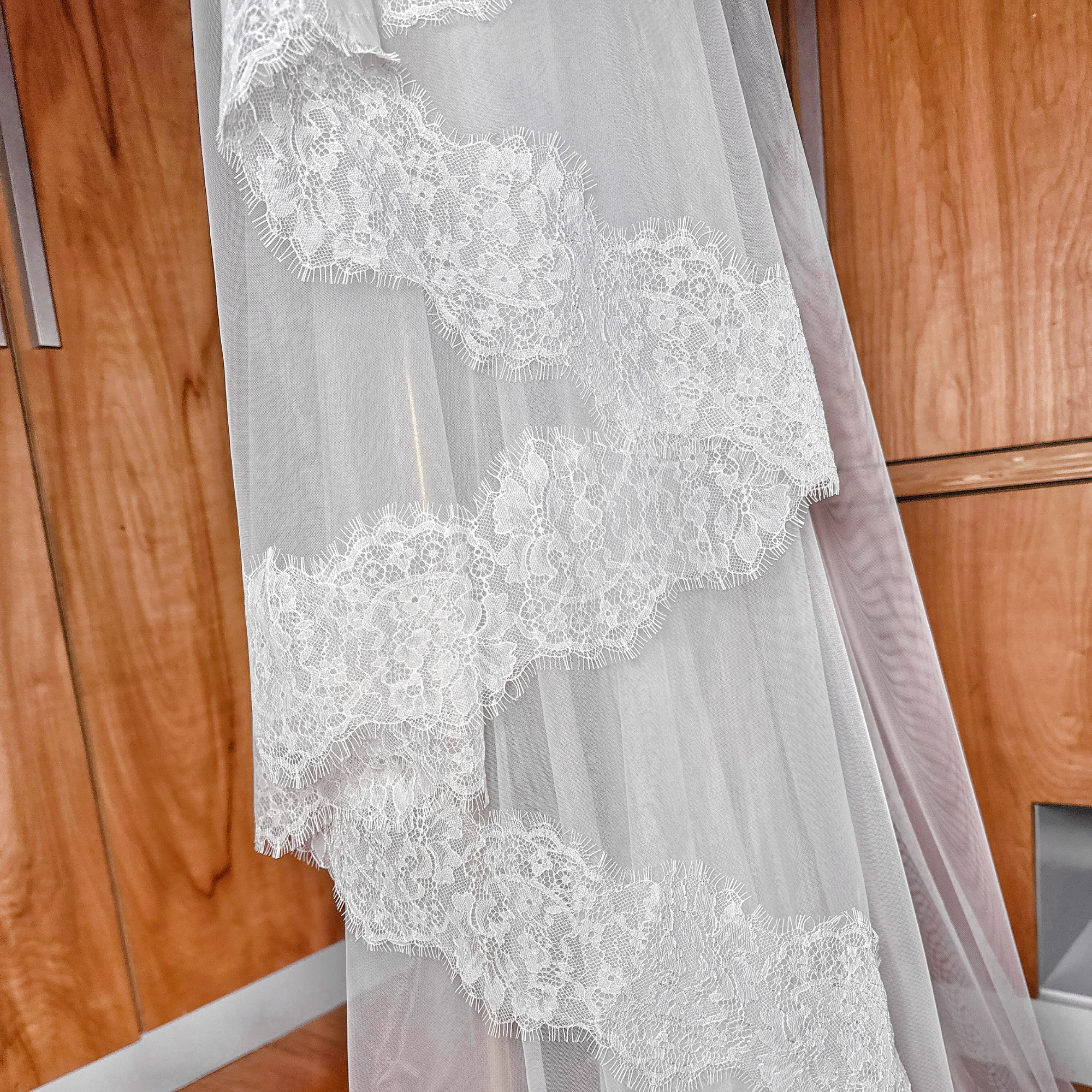 Cathedral wedding veil with a wide Chantilly lace edge and soft tulle blusher.