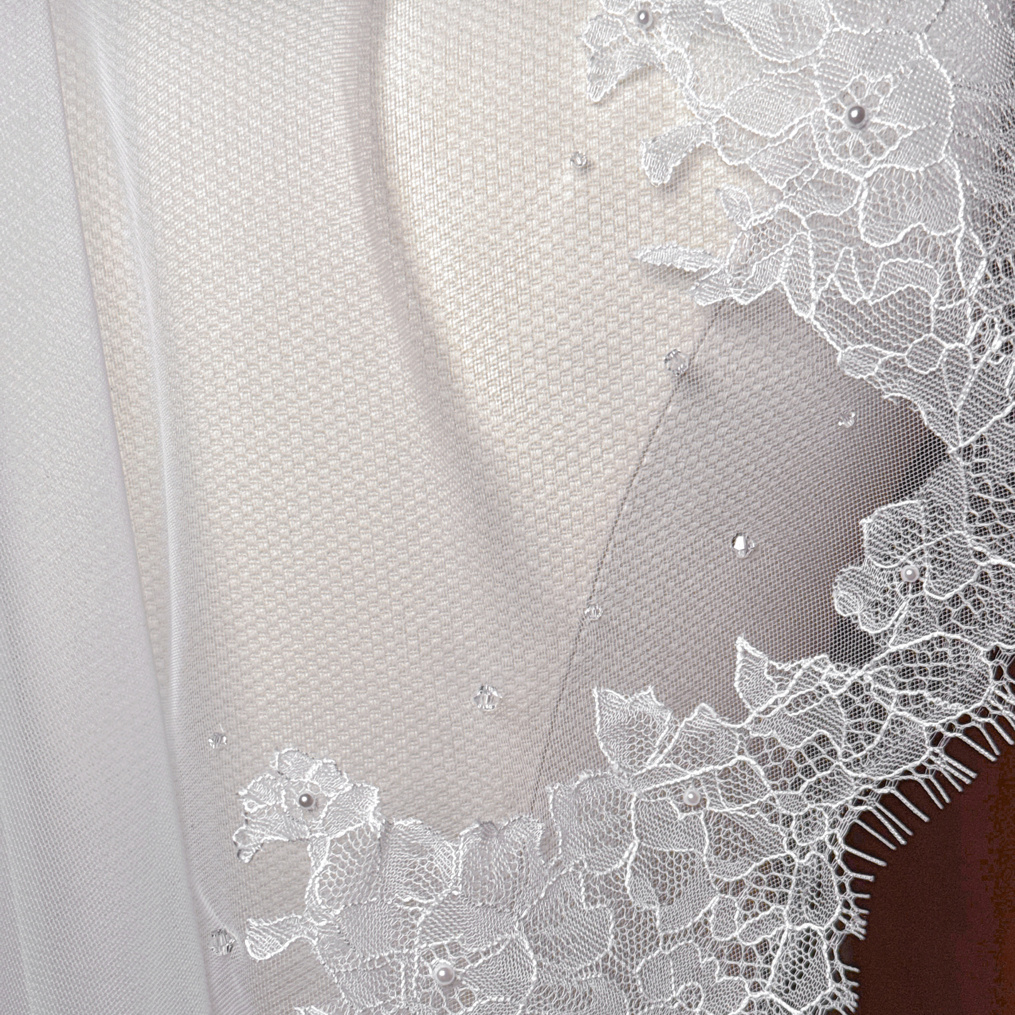 Close-up of the intricate floral French lace edging on an elbow-length mantilla veil.