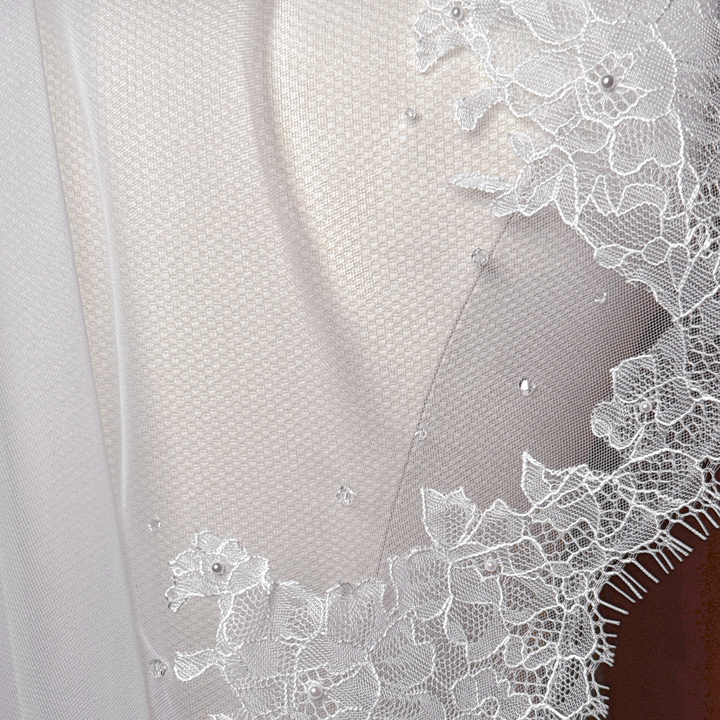 Close-up of the intricate floral French lace edging on an elbow-length mantilla veil.