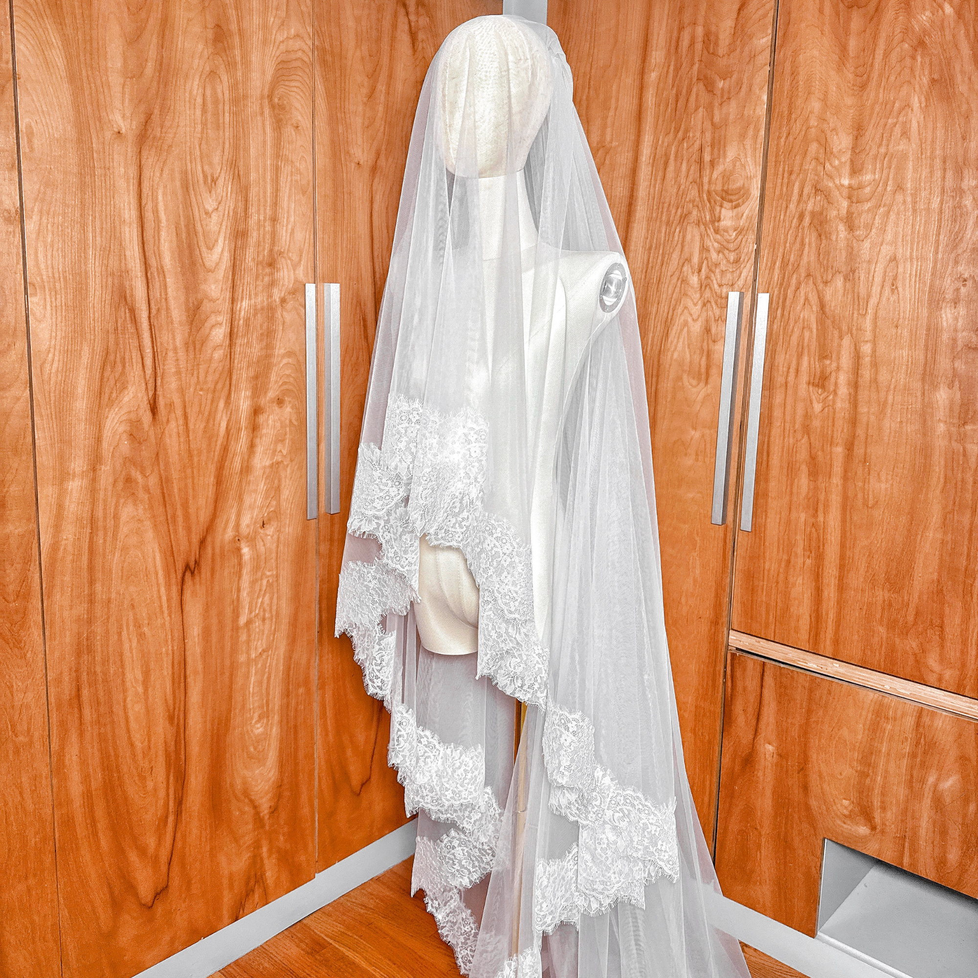Two-tier Chantilly lace wedding veil with a sheer blusher in cathedral length.