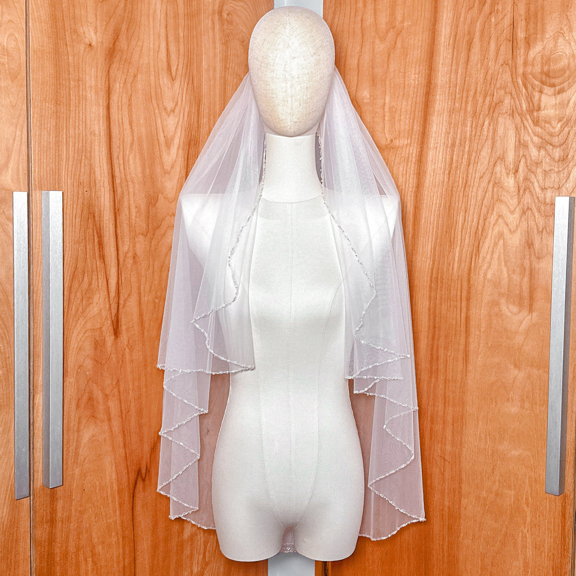 Sheer bridal fabric of a classic beaded edge wedding veil.
