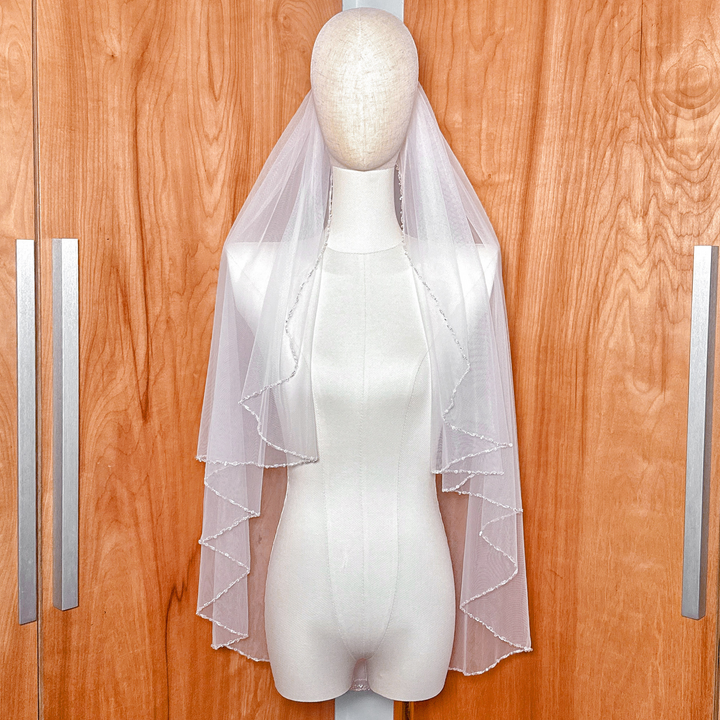 Sheer bridal fabric of a classic beaded edge wedding veil.