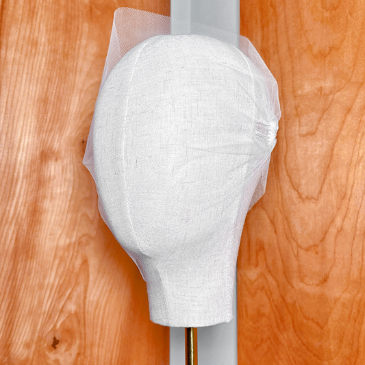 Classic white tulle bandeau wedding veil draped elegantly over a bridal mannequin head.