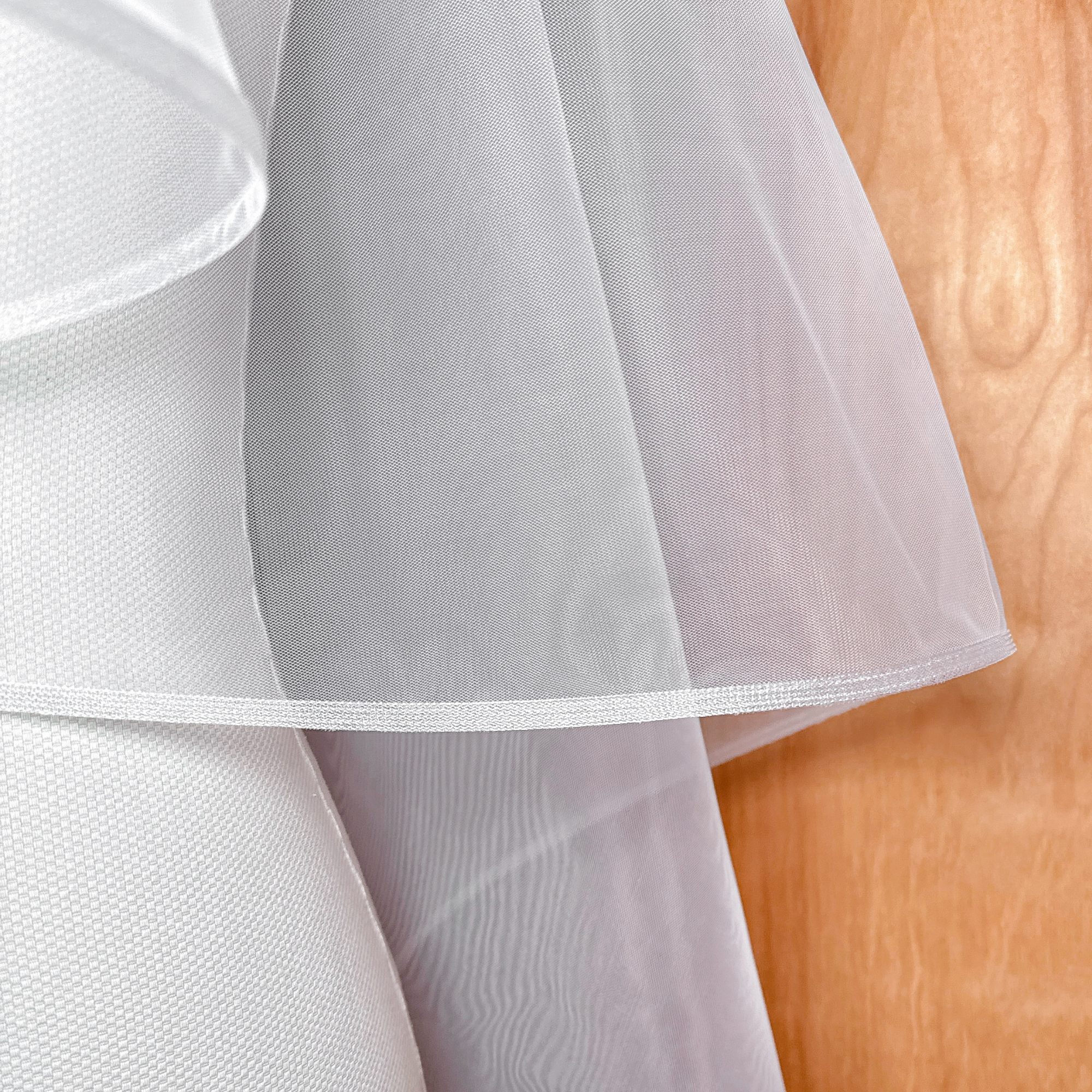 Detailed view of a two tier fingertip length veil featuring a 1/4 inch horsehair border.