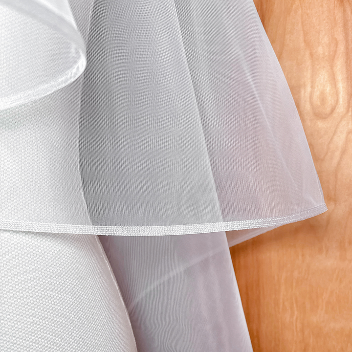 Detailed view of a two tier fingertip length veil featuring a 1/4 inch horsehair border.