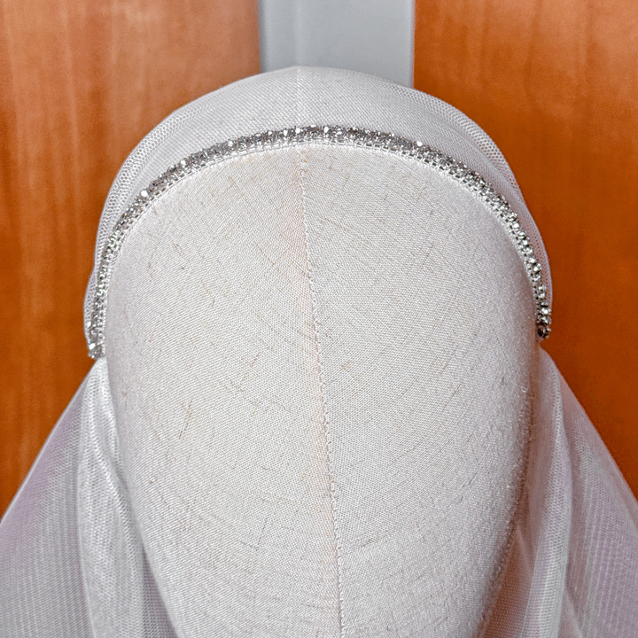Close-up of intricate beadwork on a fingertip length Juliet cap bridal veil.