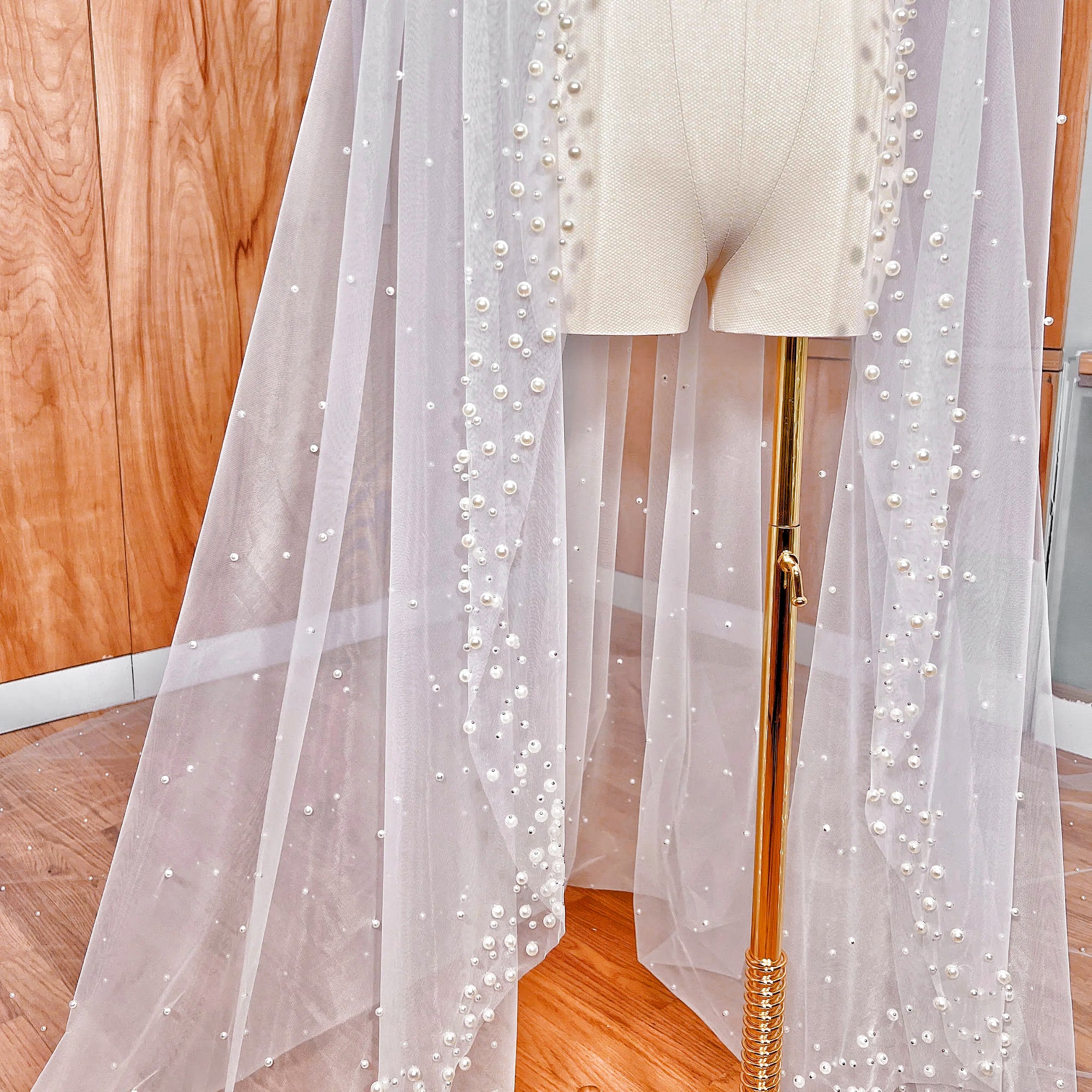 Close-up detail of the hand-beaded scattered pearl edge on a cathedral length mantilla wedding veil.