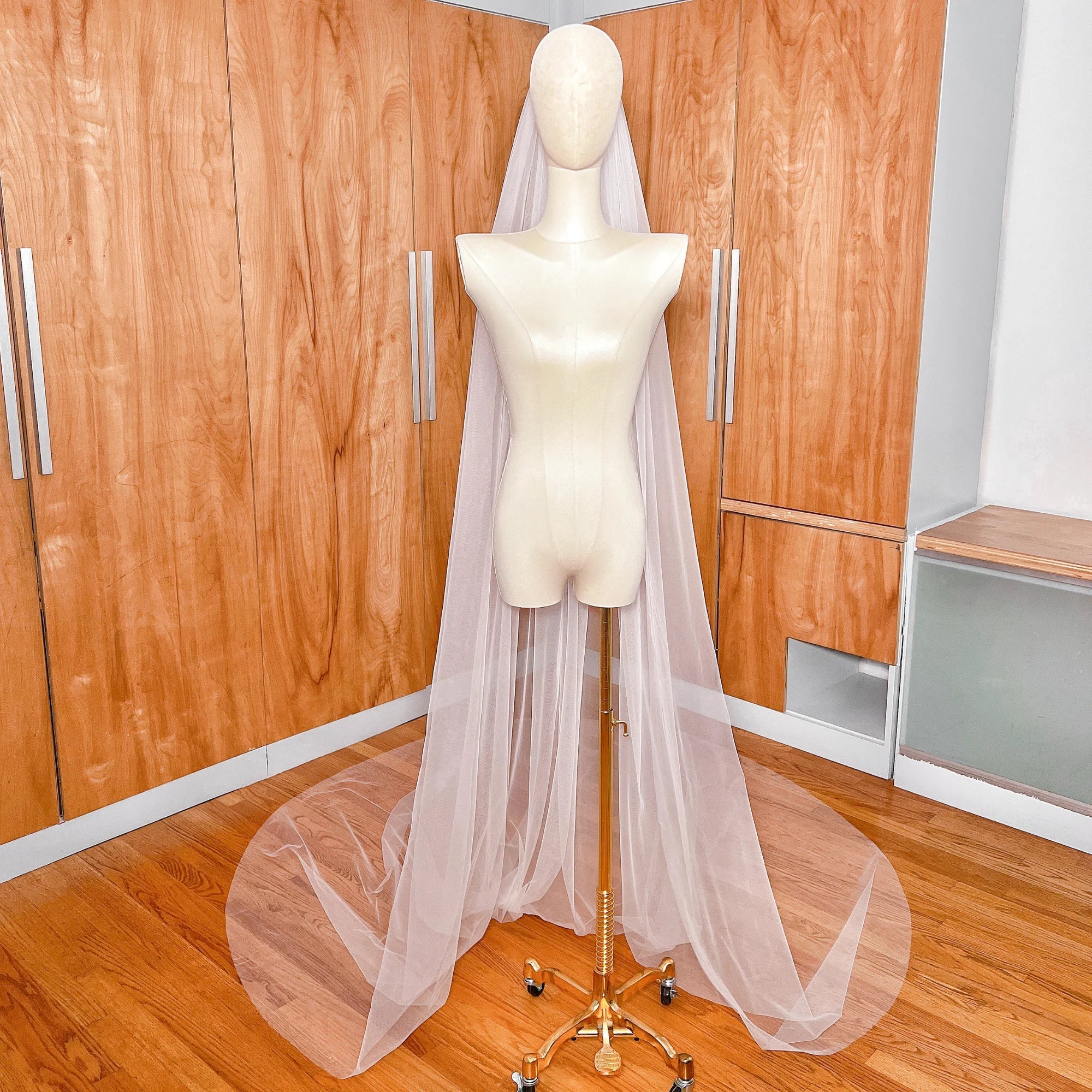 Detailed close-up showing the sheer texture and minimalist raw cut edge of a cathedral length bridal veil.