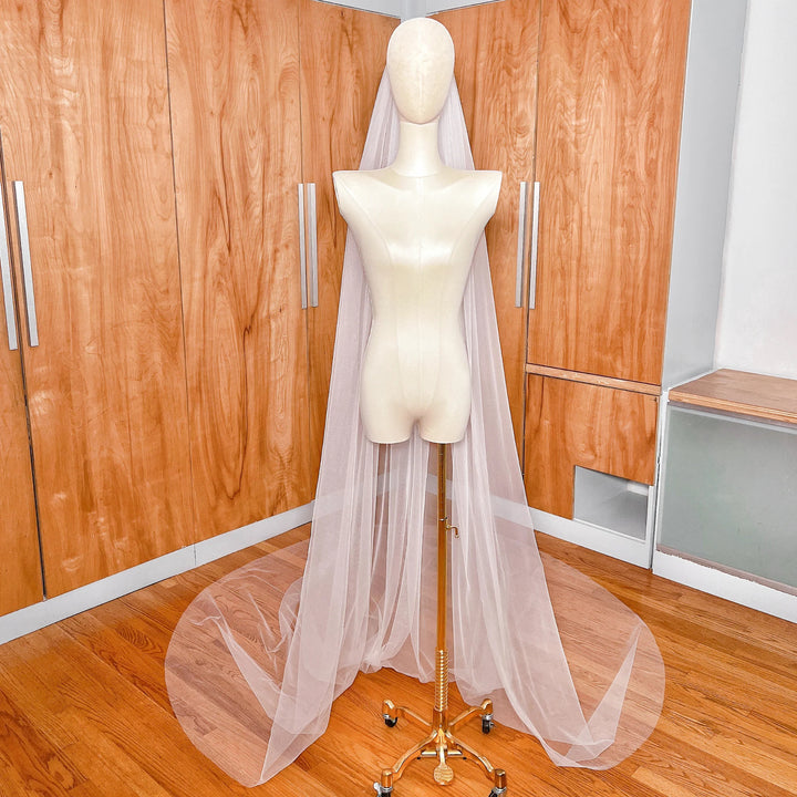 Detailed close-up showing the sheer texture and minimalist raw cut edge of a cathedral length bridal veil.
