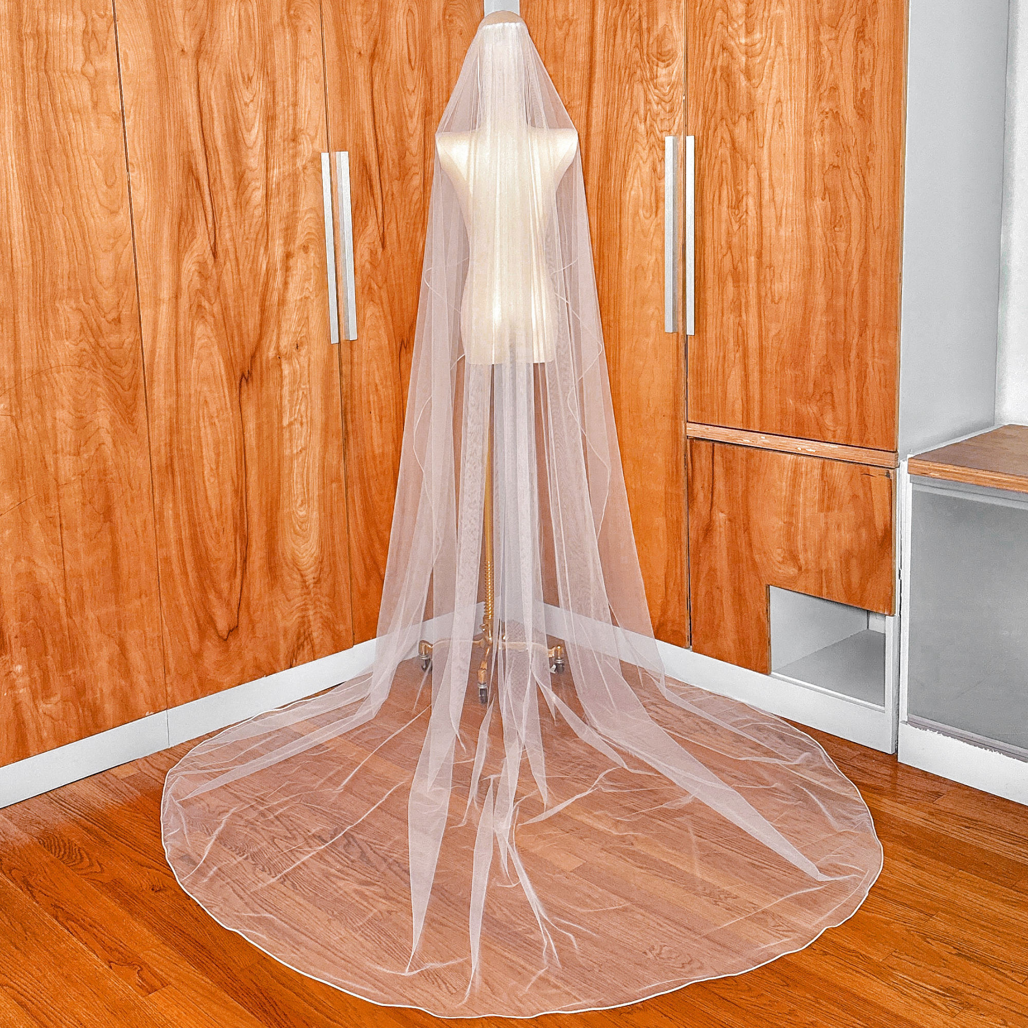 Detailed back view of the elegant corded edge trim on a cathedral length cascade wedding veil.