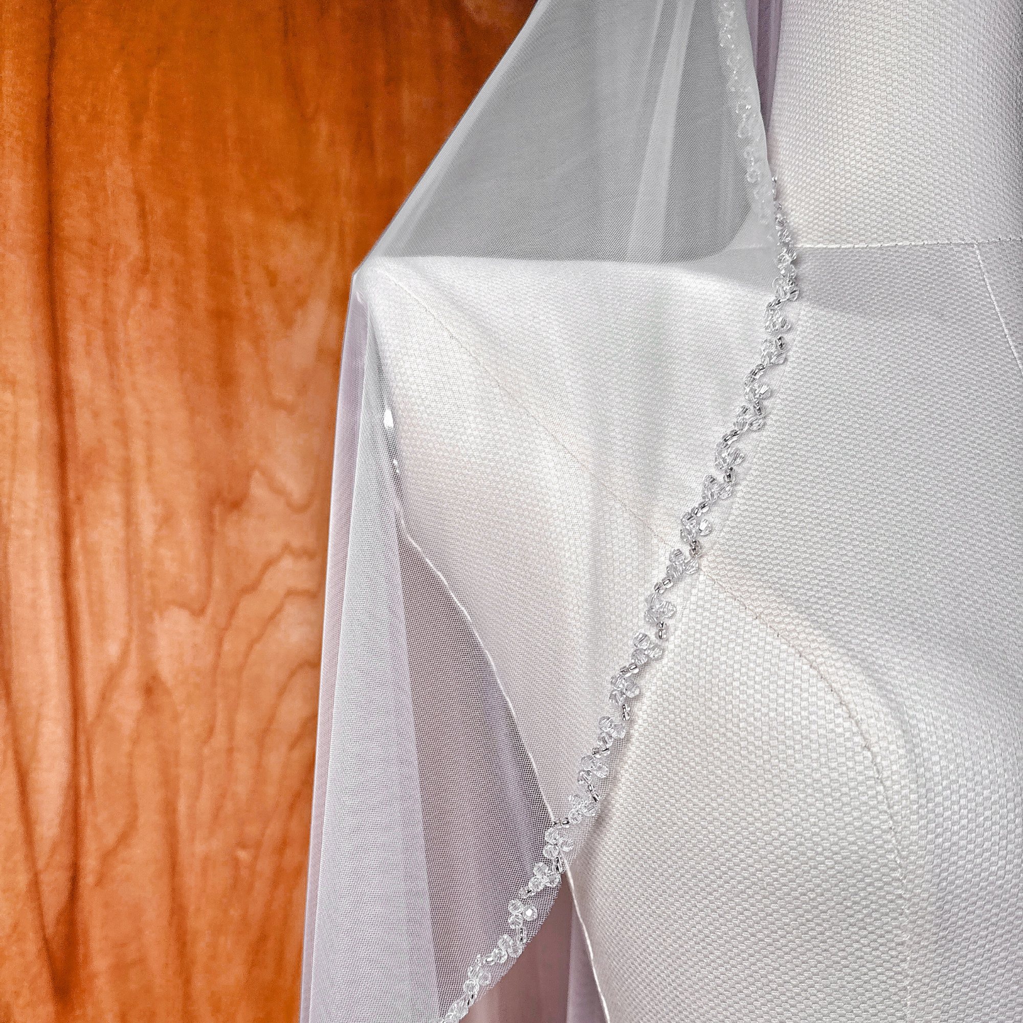 Close-up shot of the intricate crystal beaded edge on a waltz length wedding veil.