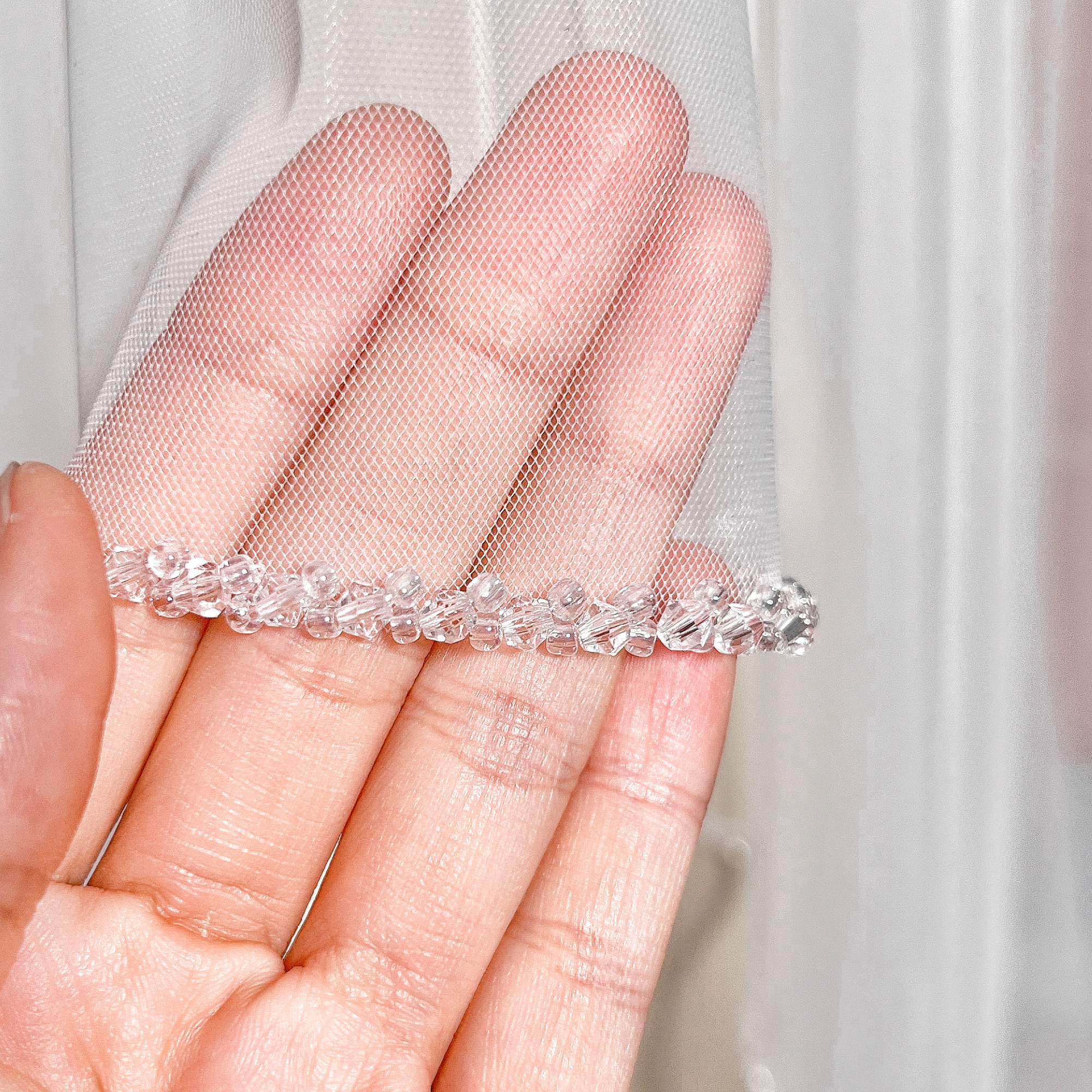 Close-up of the intricate crystal beaded edge on a cathedral length two tier wedding veil with blusher.