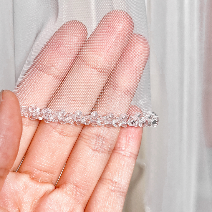 Close-up of the intricate crystal beaded edge on a cathedral length two tier wedding veil with blusher.