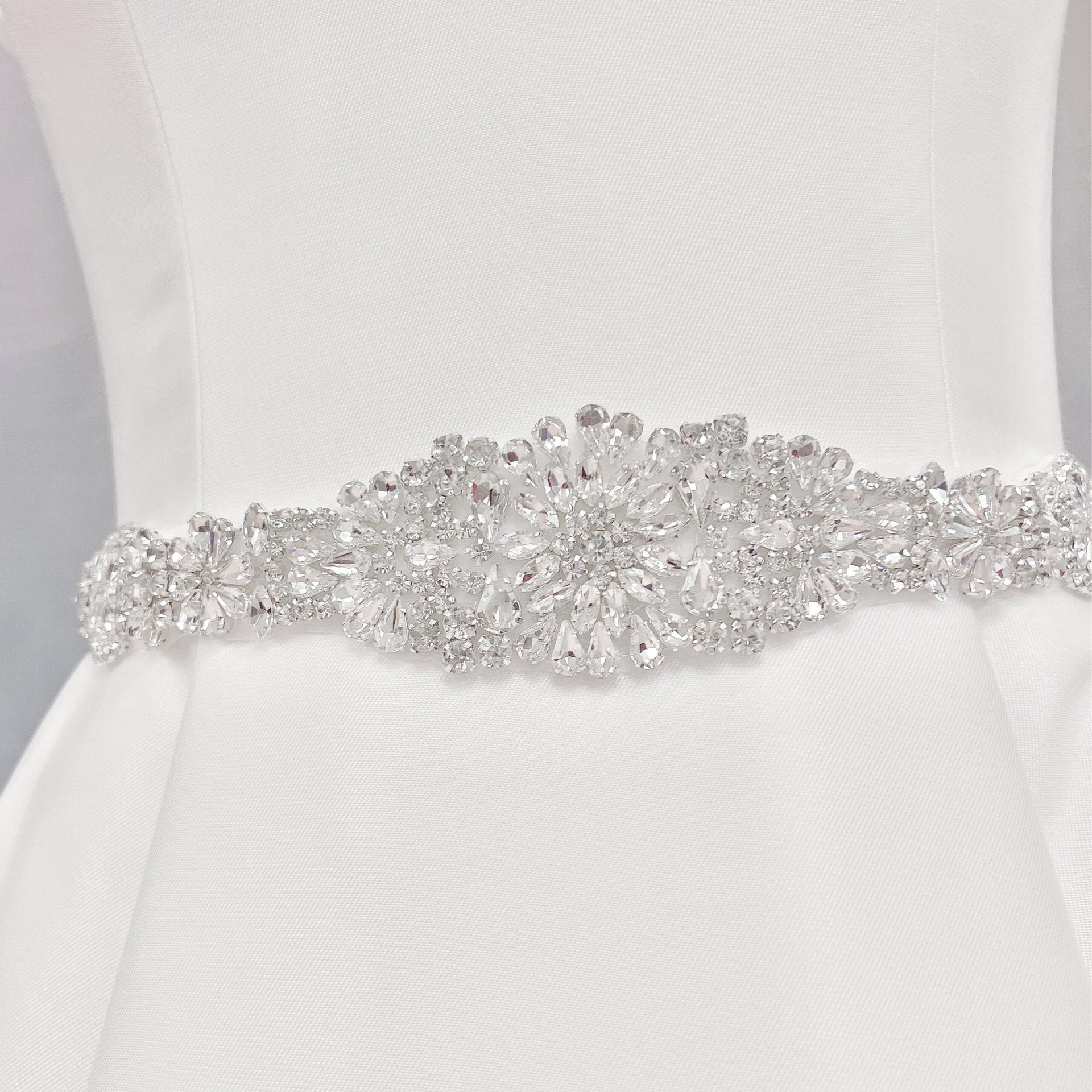 Elaborate silver crystal and Vintage Rhinestone Bridal Belt detailing on a bridal gown display.