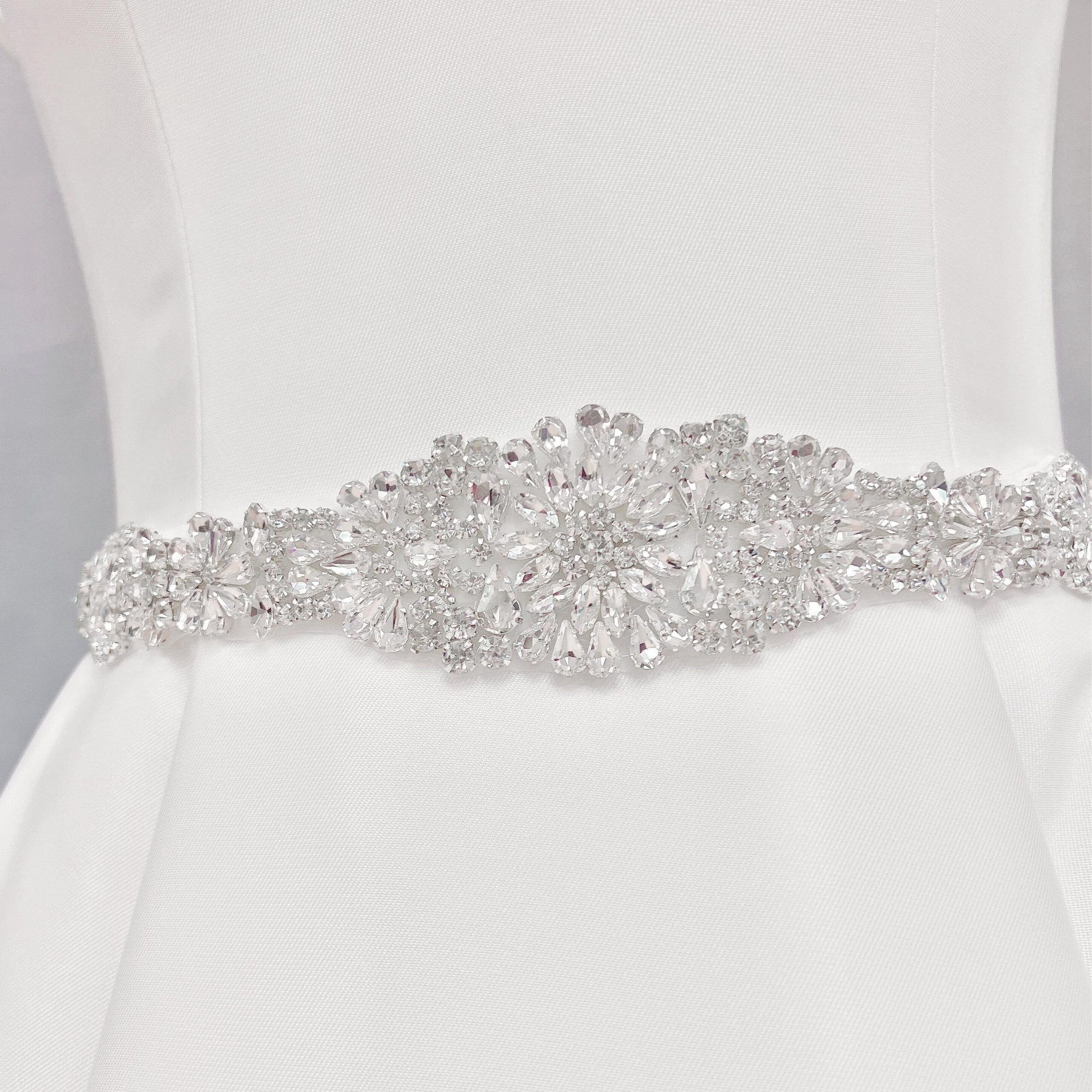 Elaborate silver crystal and Vintage Rhinestone Bridal Belt detailing on a bridal gown display.