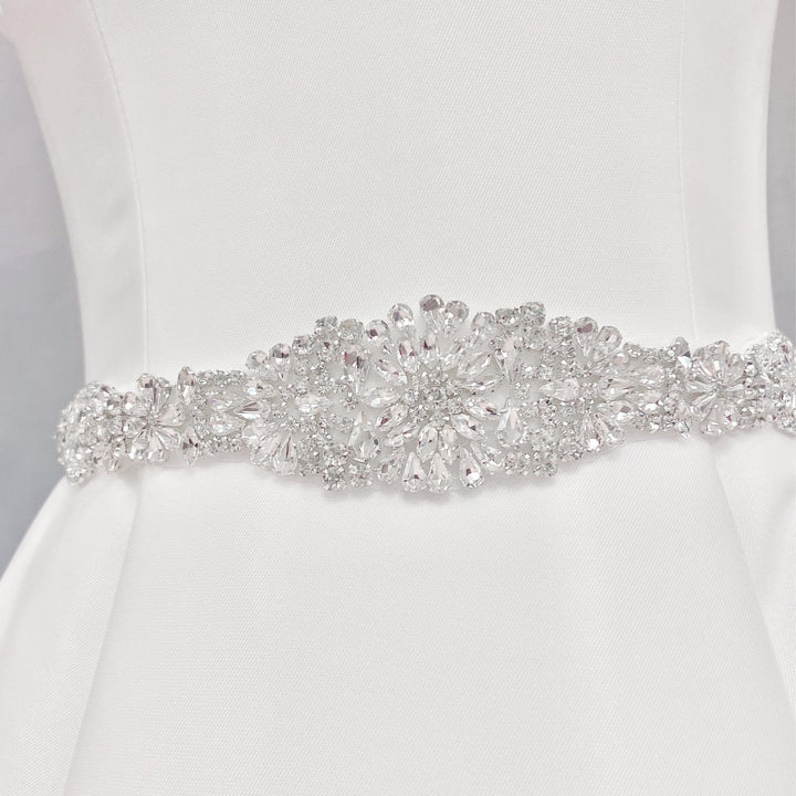 Elaborate silver crystal and Vintage Rhinestone Bridal Belt detailing on a bridal gown display.