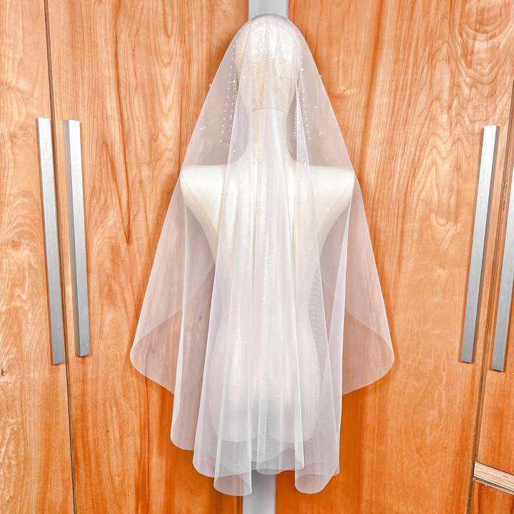 Back view of the Crystal Edge Mantilla Wedding Veil in fingertip length, showcasing the intricate crystal-beaded lace edge on a mannequin.