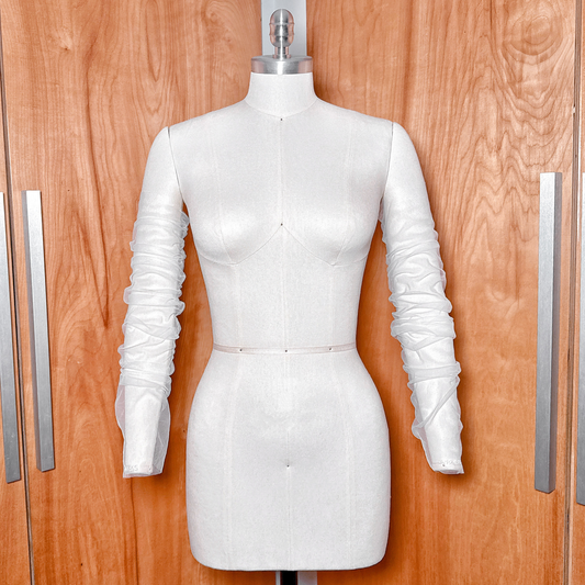 A front view of the personalized detachable ruched tulle sleeves on a dressmaker mannequin, showcasing the custom monogram on one cuff and the wedding date on the other.
