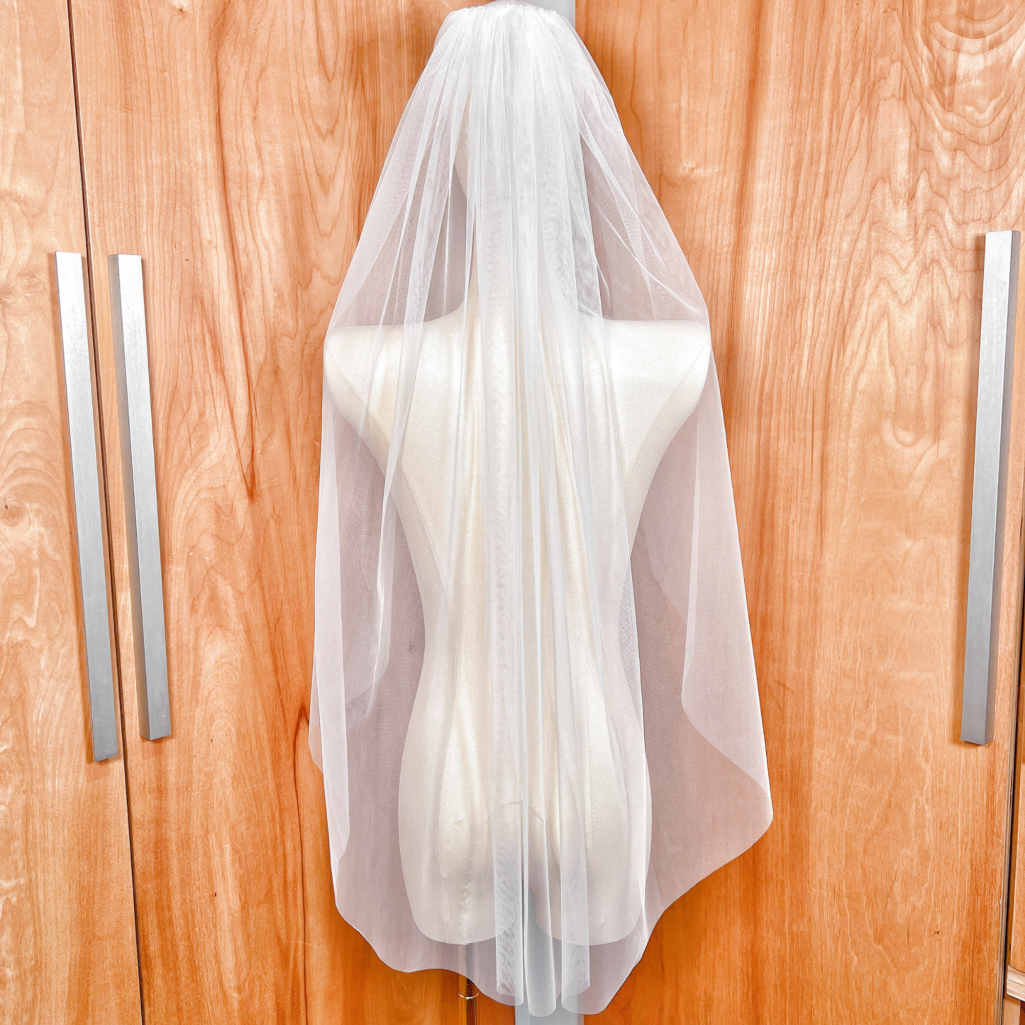 The detachable blusher veil flipped back over the head to create a classic raw edge bridal look.