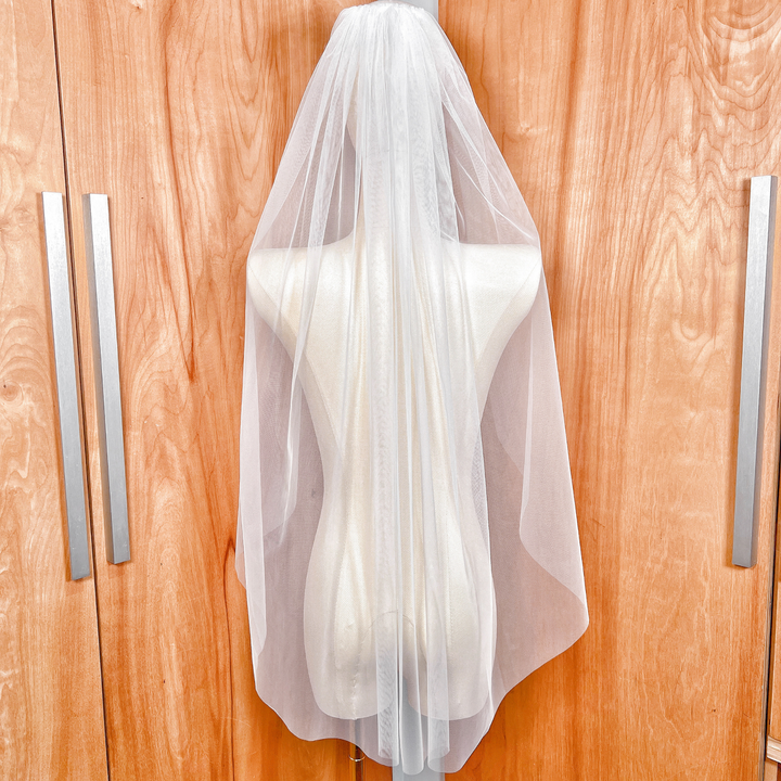 The detachable blusher veil flipped back over the head to create a classic raw edge bridal look.