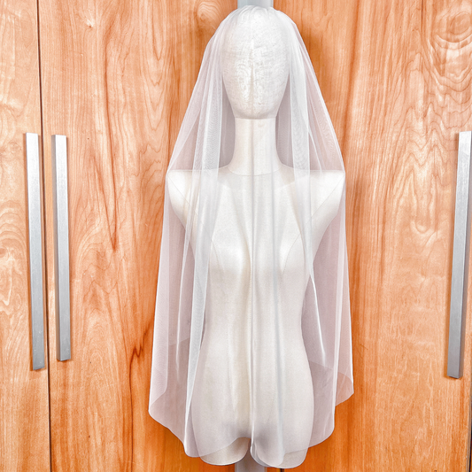 Front view of a sheer white detachable blusher veil with a minimalist raw edge finish.