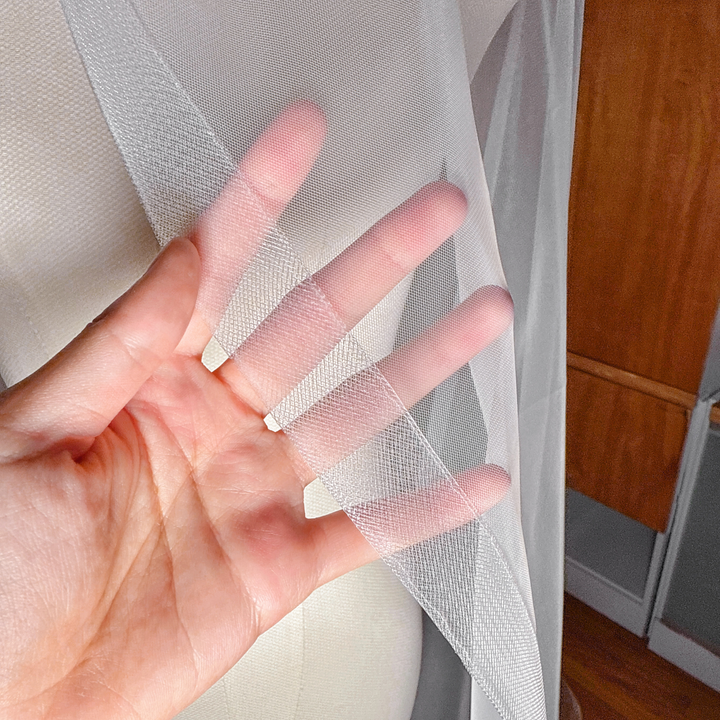 Close-up of the 1.5 inch horsehair trim on a cathedral length cascade wedding veil shown on a dress form.