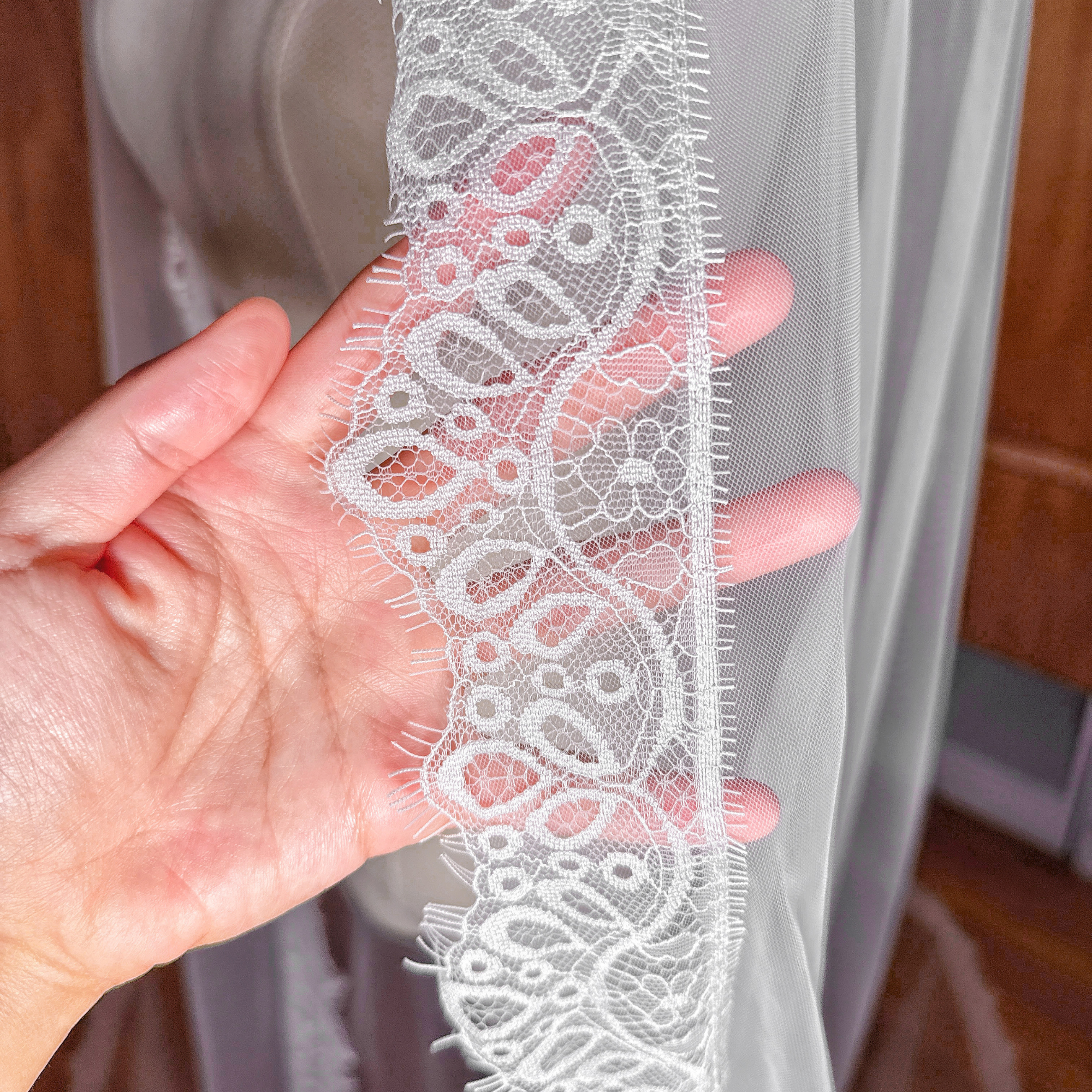 Close-up of the intricate floral Chantilly lace edge on a cathedral length bridal veil.