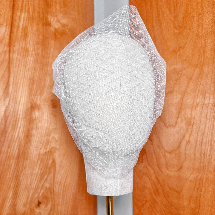 Double layer bandeau wedding veil displayed on a bridal display to show the sheer tulle layers and elegant drape.