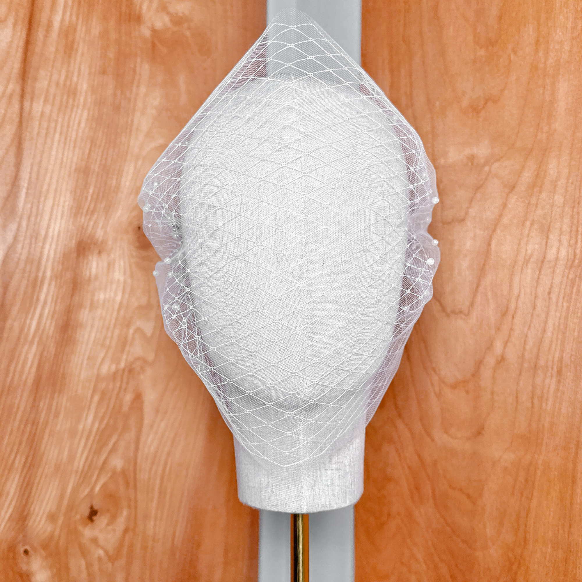 High-resolution texture shot demonstrating the premium sheer tulle material of the Double Layer Bandeau Wedding Veil with Pearls.