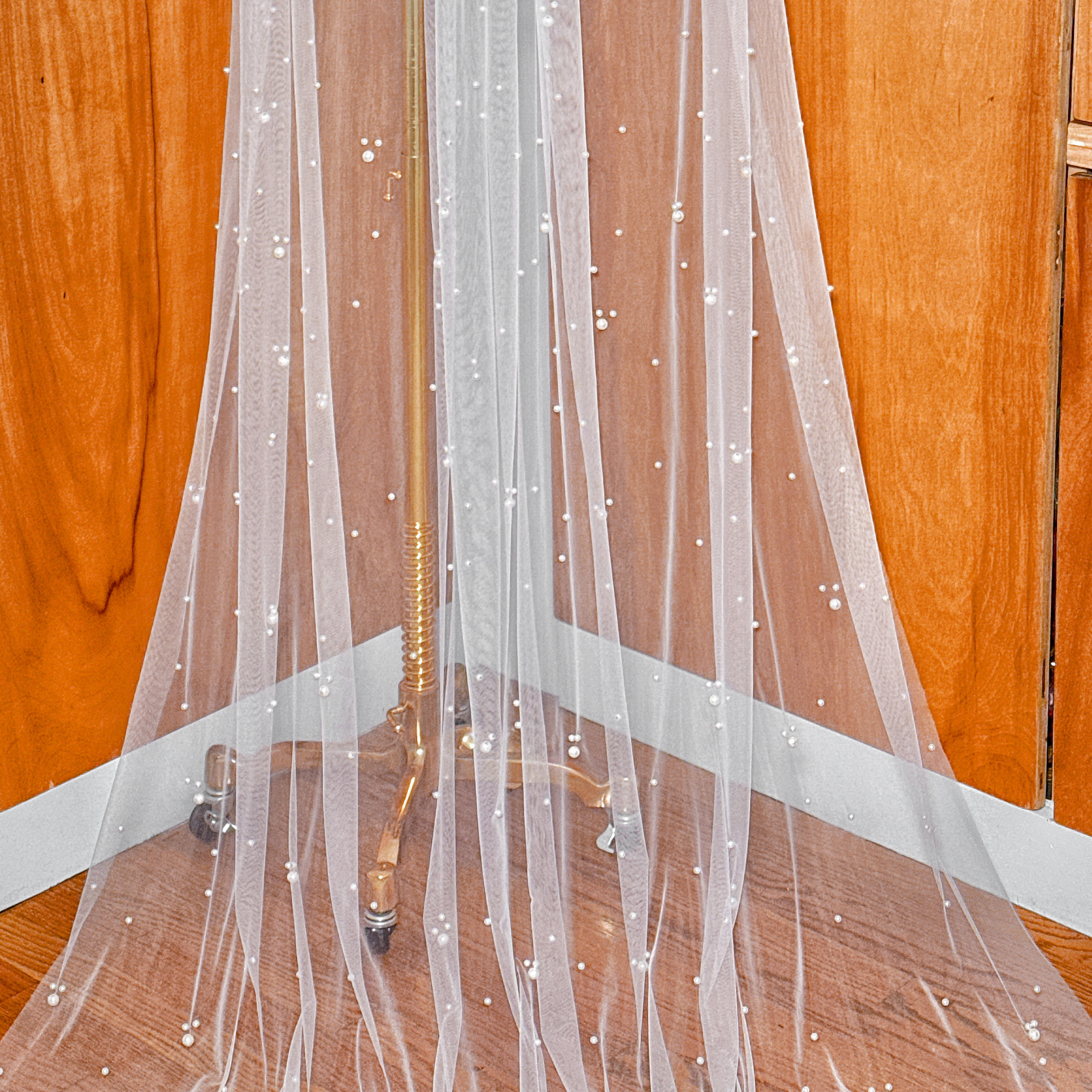 An elegant cathedral length bridal veil featuring a beautiful scattered pearl design for a modern wedding style.