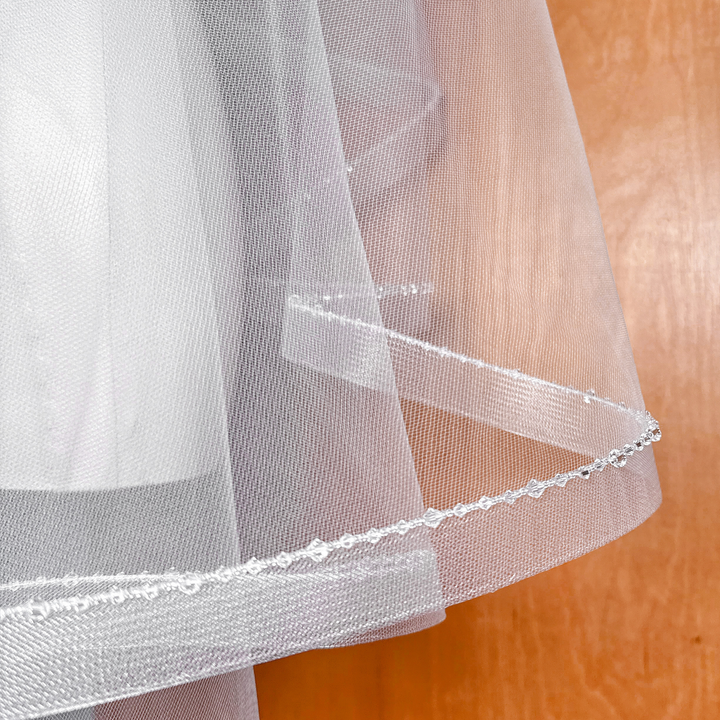 Detailed texture of the horsehair braid and crystal trim on a two tier fingertip veil.