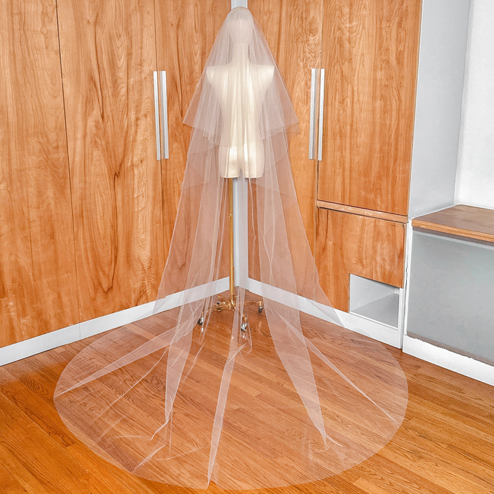 Elegant two-tier cathedral tulle wedding veil with a clean raw edge design.