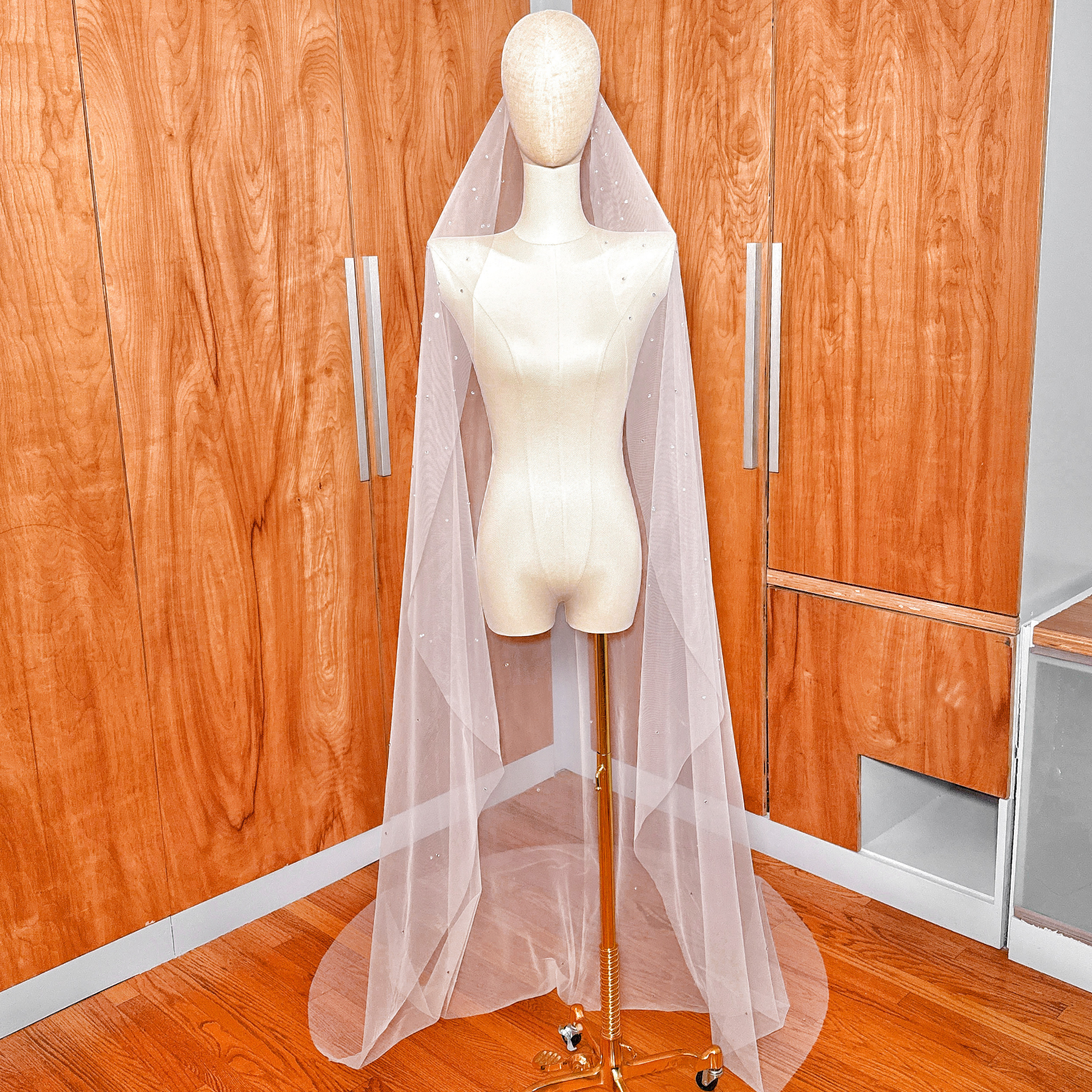 Elegant cathedral length draping of a scattered rhinestone mantilla wedding veil.