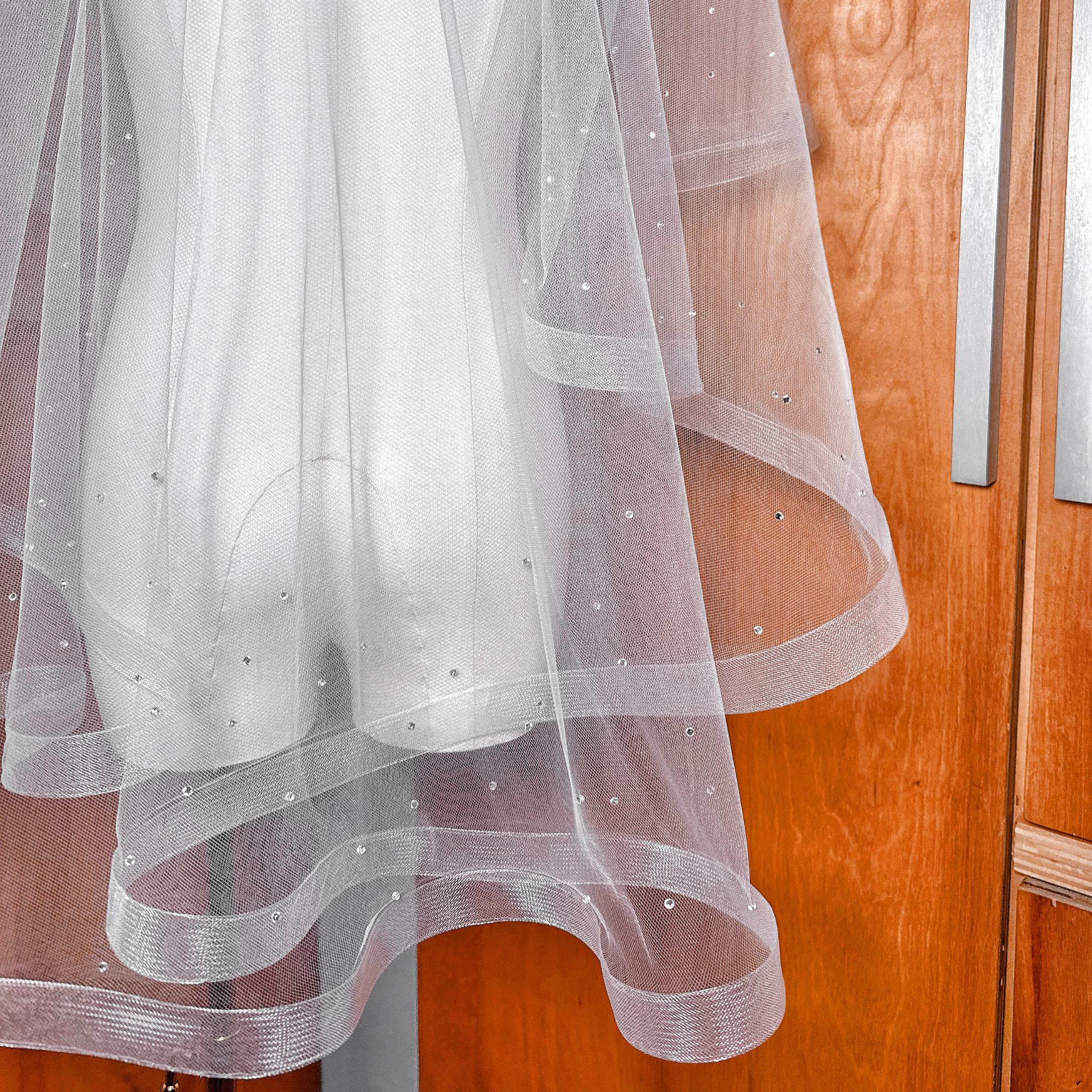 Fingertip length bridal accessory featuring a two tier horsehair wedding veil with scattered rhinestones.