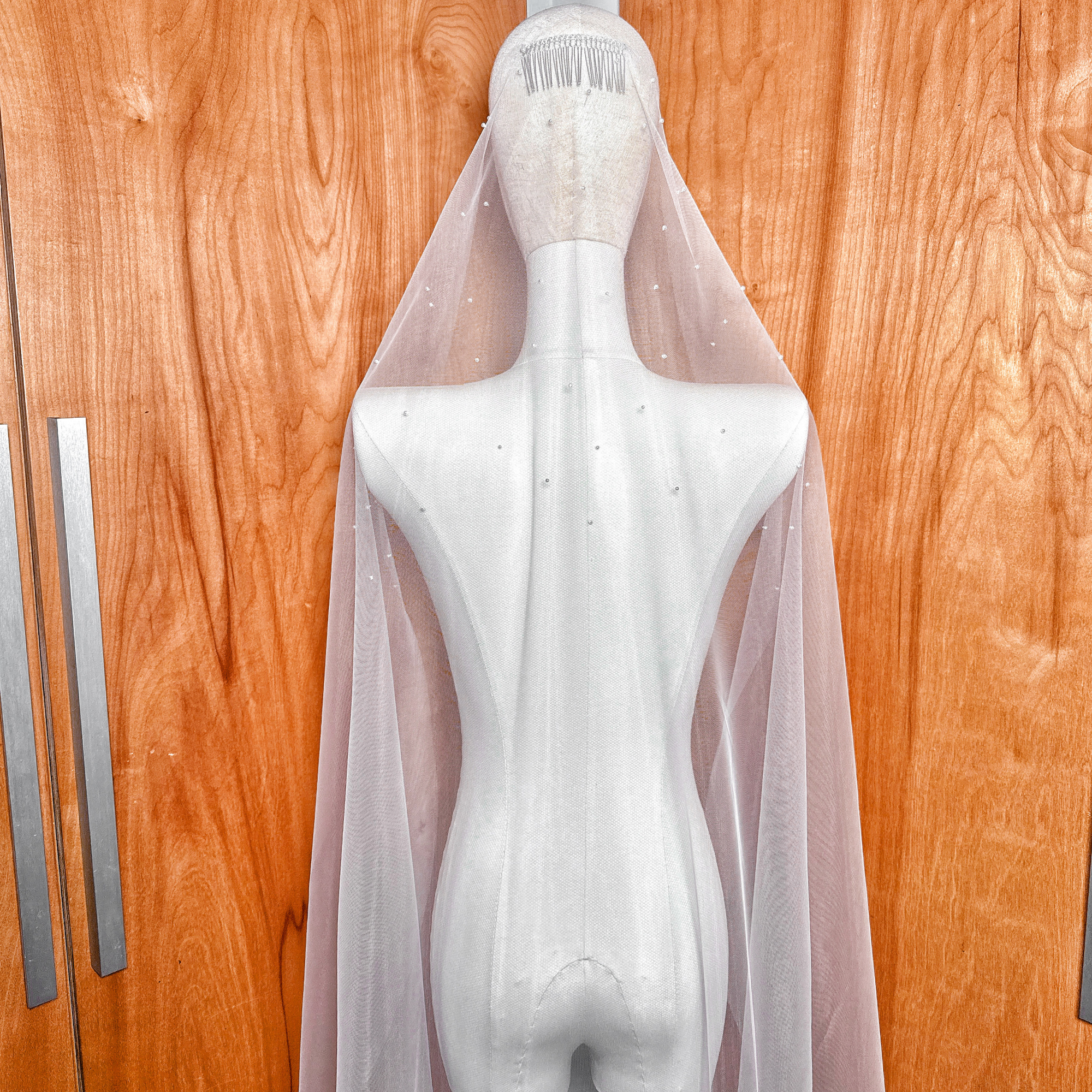 An elegant waltz length wedding veil featuring a scattered pearl pattern.
