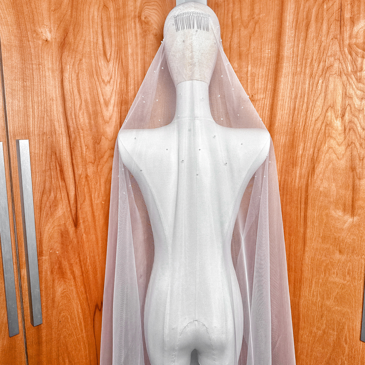 An elegant waltz length wedding veil featuring a scattered pearl pattern.